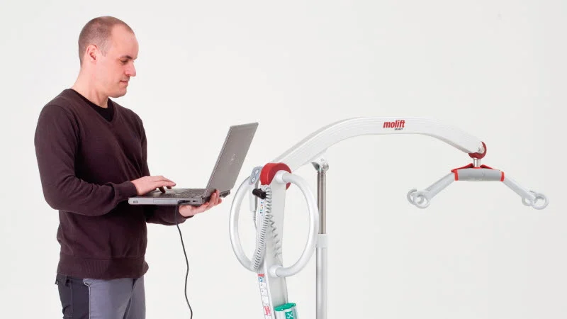 Tekniker forbinder en Molift-lift til Service Tool fra sin bærbare